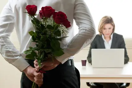 Excited and surprised businesswoman receiving red roses