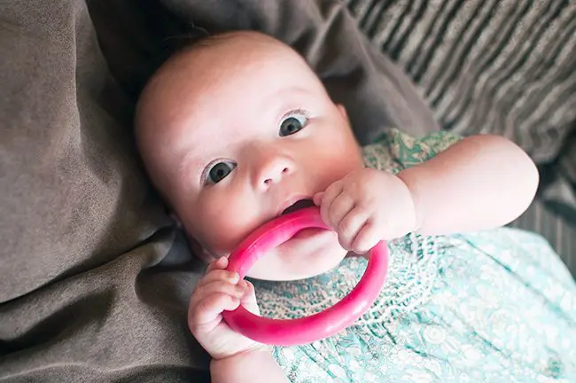Young-baby-chewing-Pink-bangle-close-up-1