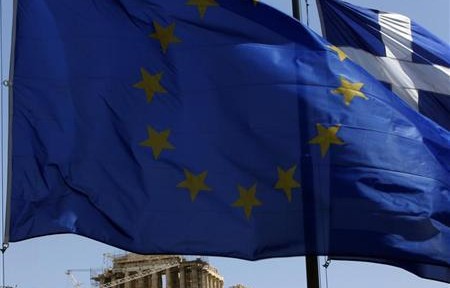 A E.U. flag and a Greek flag flutter in front of the monument of Parthenon on Acropolis hill in Athen